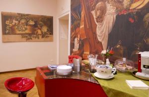 een tafel met een rode stoel en een schilderij aan de muur bij Spaccanapoli B&B City Soul in Napels