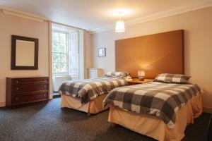 a bedroom with two beds and a large window at Dundee Backpackers Hostel in Dundee