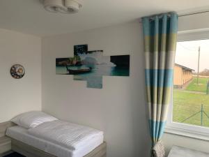 ein weißes Zimmer mit einem Bett und einem Fenster in der Unterkunft Hotel Am Spielacker in Gelnhausen