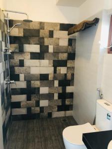 a bathroom with a checkered wall at OCEAN EDGE HIKKA in Hikkaduwa