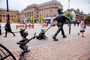 a statue of two children playing with two statues at Dundee Backpackers Hostel in Dundee