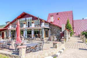 un restaurante con mesas, sillas y sombrillas en Hotel Cheia, en Cheia