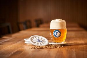a glass of beer sitting on a wooden table at Hotel Kleis in Cvikov