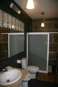 a bathroom with a sink and a toilet and a mirror at Quinta das Aranhas in Castelo de Paiva