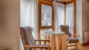 - une table et des chaises dans une chambre avec fenêtre dans l'établissement Saplan Real Estate MONTLUDE, à Les