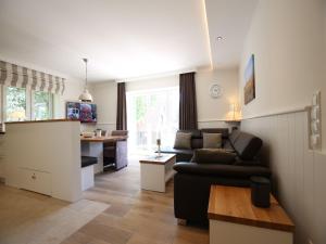 ein Wohnzimmer mit einem Sofa und einer Küche in der Unterkunft Blanker Hans Wohnung 4 in Wangerooge