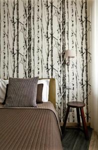 a bedroom with a bed with a tree wallpaper at 15 Quindici by Serendipity Rooms in Milan