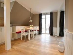 cocina y comedor con mesa y sillas en Charlotte 48 - Wunderschöne Ferienwohnung mit Balkon und Sauna en Wangerooge