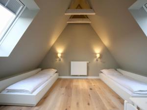 a room with two beds in a attic at Charlotte 48 - Wunderschöne Ferienwohnung mit Balkon und Sauna in Wangerooge
