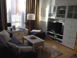 a living room with a couch and a tv at Kaiserhof Apartment 14 in Wangerooge