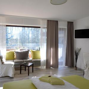 a living room with a couch and a large window at Waldpension Bielefeld in Bielefeld