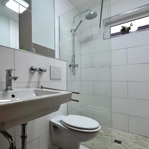 Baño blanco con aseo y lavamanos en Waldpension Bielefeld, en Bielefeld