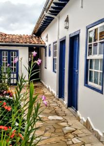 a house with blue doors and a stone walkway at Pousada Sinhá Vilaça in Tiradentes