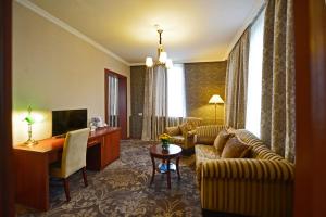 a living room with a couch and a desk at Hotel Astoria Tbilisi in Tbilisi City