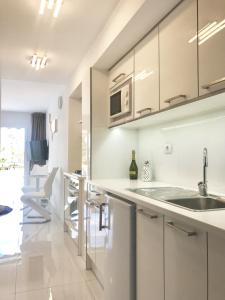 a kitchen with white cabinets and a sink at Style Apartment with Ocean view in Playa de las Americas