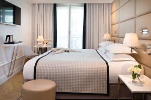 a hotel room with a large bed and a window at H&ocirc;tel R de Paris - Boutique Hotel in Paris