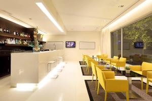 restauracja z żółtymi krzesłami i barem w obiekcie Exe Puerto de Sagunto w mieście Puerto de Sagunto