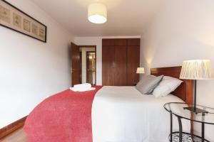 リスボンにあるModern Graca by Homingのベッドルーム(赤い敷物付きの白い大型ベッド1台付)