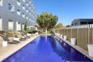 basen z leżakami obok budynku w obiekcie Exe Puerto de Sagunto w mieście Puerto de Sagunto