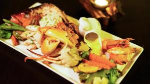 a plate of food with shrimp and vegetables on a table at BeachMirissa Hotel in Mirissa