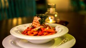 a bowl of pasta on a plate on a table at BeachMirissa Hotel in Mirissa