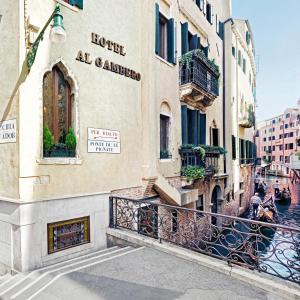 ヴェネツィアにあるアンティカ ロカンダ アル ガンベーロの運河のそばにバルコニー付きの建物