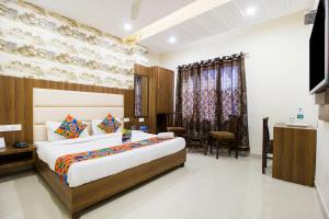 a hotel room with a bed and a dining room at FabHotel Royal Villa Hussainpura Chowk in Amritsar