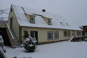 una casa con techo cubierto de nieve en la nieve en Arnold´s Ferienhof, en Stadtlauringen
