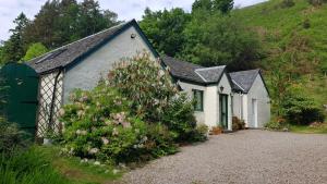 a row of small white houses on a hill at The Old Cottage in Arduaine