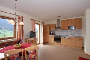 a kitchen with a table and a dining room at Bauernhof Hundbichl in Brixen im Thale