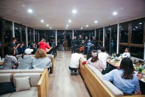 a group of people sitting at tables in a restaurant at Hotel Banguriani in Mestia