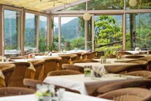 um restaurante com mesas, cadeiras e janelas em Residence Tannhof em Caldaro