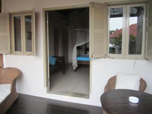 um quarto com uma mesa de jantar e um quarto com uma janela em Kembali Beach Bungalows em Amed