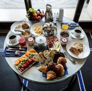 a table topped with plates of food and drinks at Hôtel Brighton - Esprit de France in Paris