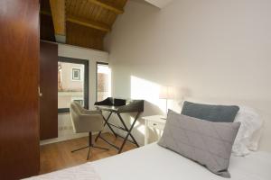 a bedroom with a bed with a desk and a chair at Amazing Tailor Made Penthouse With a View in Lisbon