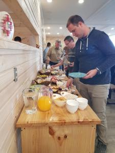 um grupo de homens preparando comida em uma mesa em PAMPA HOSTEL em Torres del Paine