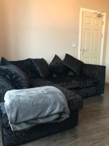 a black couch with pillows in a living room at 59 Wern Fawr Road in Swansea