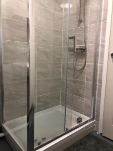 a shower stall with a glass door with a shower at 59 Wern Fawr Road in Swansea