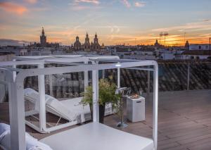 a hotel room with a balcony overlooking the ocean at CoolRooms Palacio Villapanés in Seville