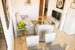 sala de estar con sofá, sillas y TV en Apartment in Palm Mar PM109, en Palm-mar
