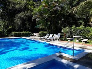 uma piscina com duas cadeiras e uma mesa ao lado em Albergue de Montaña Talari em San Isidro
