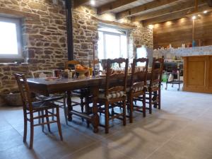 a dining room with a wooden table and chairs at La Ferme de Kerhors in Tréméoc