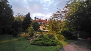 a large house in the middle of a garden at Rosehill Cottage in Orbányosfa