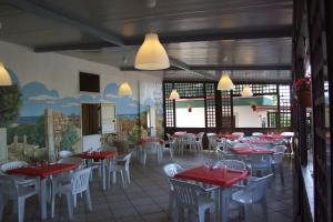 un ristorante con tavoli rossi e bianchi e sedie bianche di Happy Camp mobile homes in Camping Villaggio Internazionale a San Menaio