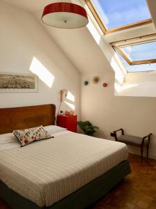a bedroom with a bed and a ceiling with skylights at Mansarda Bellini in Naples