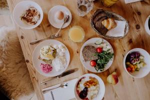 uma mesa de madeira com pratos de comida em Design Hotel Miramonte em Bad Gastein