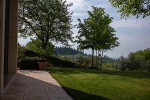 een loopbrug naar een tuin met gras en bomen bij Agriturismo Sommavalle in Verona