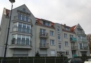 ソポトにあるGrand Apartments - Timber Apartment in Sopotの窓とフェンス付きの大きなアパートメントです。