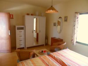 a bedroom with a bed and a cabinet and a table at Bungalows El Paradiso in Tazacorte +68 photos