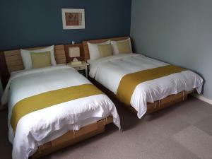 two beds sitting next to each other in a room at Hotel Gaon J Stay in Seogwipo